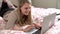 Teenage Girl Lying On Bed Using Laptop