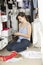 Teenage Girl On Mobile Phone Surrounded By Clothes In Wardrobe