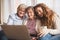 A teenage girl, mother and grandmother with laptop at home.