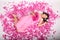 Teenage girl in pink dress with bouquet of peonies lying on petals