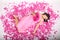 Teenage girl in pink dress with bouquet of peonies lying on petals