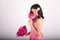Teenage girl in pink dress smelling peonies