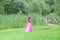 Teenage Girl in Pink Prom Dress Running in Grass