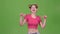 Teenage girl in a pink top is delighted with the victory. Green screen