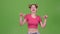 Teenage girl in a pink top is delighted with the victory. Green screen. Slow motion