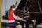 Teenage girl playing grand piano