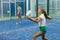 Teenage girl playing padel game on court