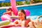 Teenage girl pool swim on inflatable pink flamingo