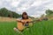 Teenage girl portrait photography with acoustic guitar model posing outdoor green field peaceful summer June day time nature