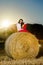 Teenage girl posing at the evening on haystack, sunset colors