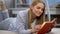 Teenage girl reading book, dreaming of romantic love, imagining heroic man