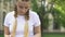 Teenage girl reading book outdoors, remembering information, preparing for exam