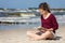 Teenage girl reading book sitting on beach
