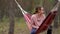 Teenage girl relaxing in hammock under trees. Female teen resting in weekend