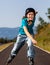 Teenage girl rollerblading against blue sky