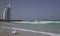 Teenage girl shoots on smartphone the sea waves on Public Jumeirah Open Beach on the coast of the Persian Gulf, Dubai