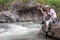 A teenage girl sits on the bank of a stream