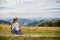 A teenage girl sits on her back on the mountain