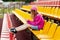 A teenage girl sits on the school bleachers and writes a message on her phone in her free time