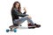Teenage girl sitting on a longboard and making a peace gesture