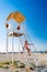 Teenage girl sitting on stairs lifeguard tower on beach against cloudless sky