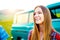 Teenage girl smiling against green campervan outside in nature