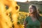 Teenage girl smiling while looking at sunflowers