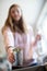 Teenage Girl Sorting Recycling Into Kitchen Bin At Home