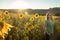 Teenage girl standing in front of sunflowers