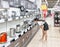 A teenage girl in a store gets acquainted with household electrical appliances