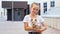 Teenage girl in t-shirt holds small puppy in arms smiling