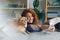 Teenage girl taking selfie with cute puppy using smartphone at home