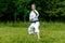 Teenage girl training karate kata outdoors, performs soto uke or outside block in kakutsu dachi stand