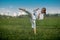 Teenage girl training karate kata outdoors, performs the uro mawashi geri hook kick