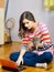 Teenage girl using notebook in her room while holding dog puppy