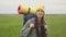 Teenage girl walks across green field carrying backpack