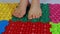 A teenage girl walks on orthopedic massage mats puzzles. Prevention of flat feet and foot massage.