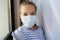 A teenage girl wears a protective medical disposable mask.