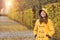 Teenage girl in a yellow hooded coat in Augarten park Vienna autumn