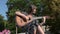 Teenage girls playing the guitar in the park. Girl play solo guitar in green nature park