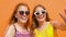 Teenage girls in sunglasses showing thumbs up