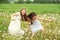 teenage girls on a walk with their sister and dog in a summer field with dandelions sunny day