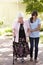 Teenage Granddaughter Helping Grandmother Out On Walk