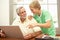 Teenage Grandson Helping Grandfather To Use Laptop