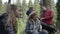 Teenage group of friends spending time in nature singing and cheering in the forest -