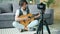 Teenage guitarist recording video for internet blog holding guitar at home