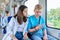 Teenage guy and girl commuter train passengers sitting together looking at smartphone