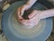 Teenage hands over the potter`s wheel. Sculpt from clay in a pottery workshop. Traditional pottery craft. Ceramics workshop