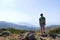 Teenage hiker admiring the view from the top of a hill.