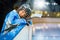 Teenage hockey player leans on the boards of rink